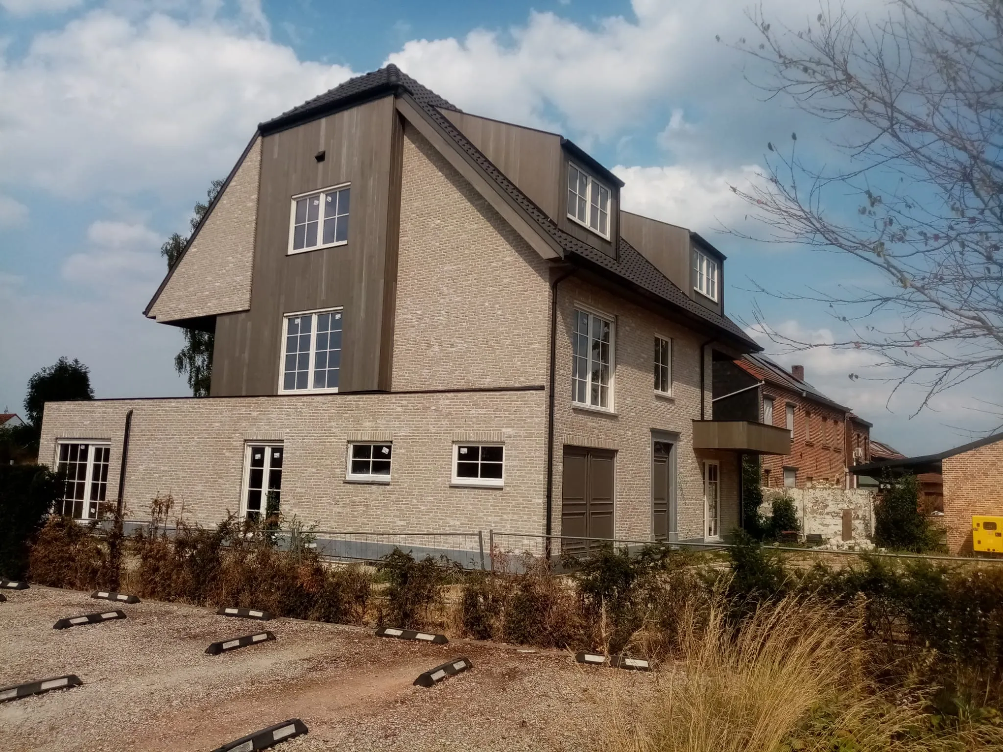 Zijgevel van de afgewerkte meergezinswoning in Holsbeek