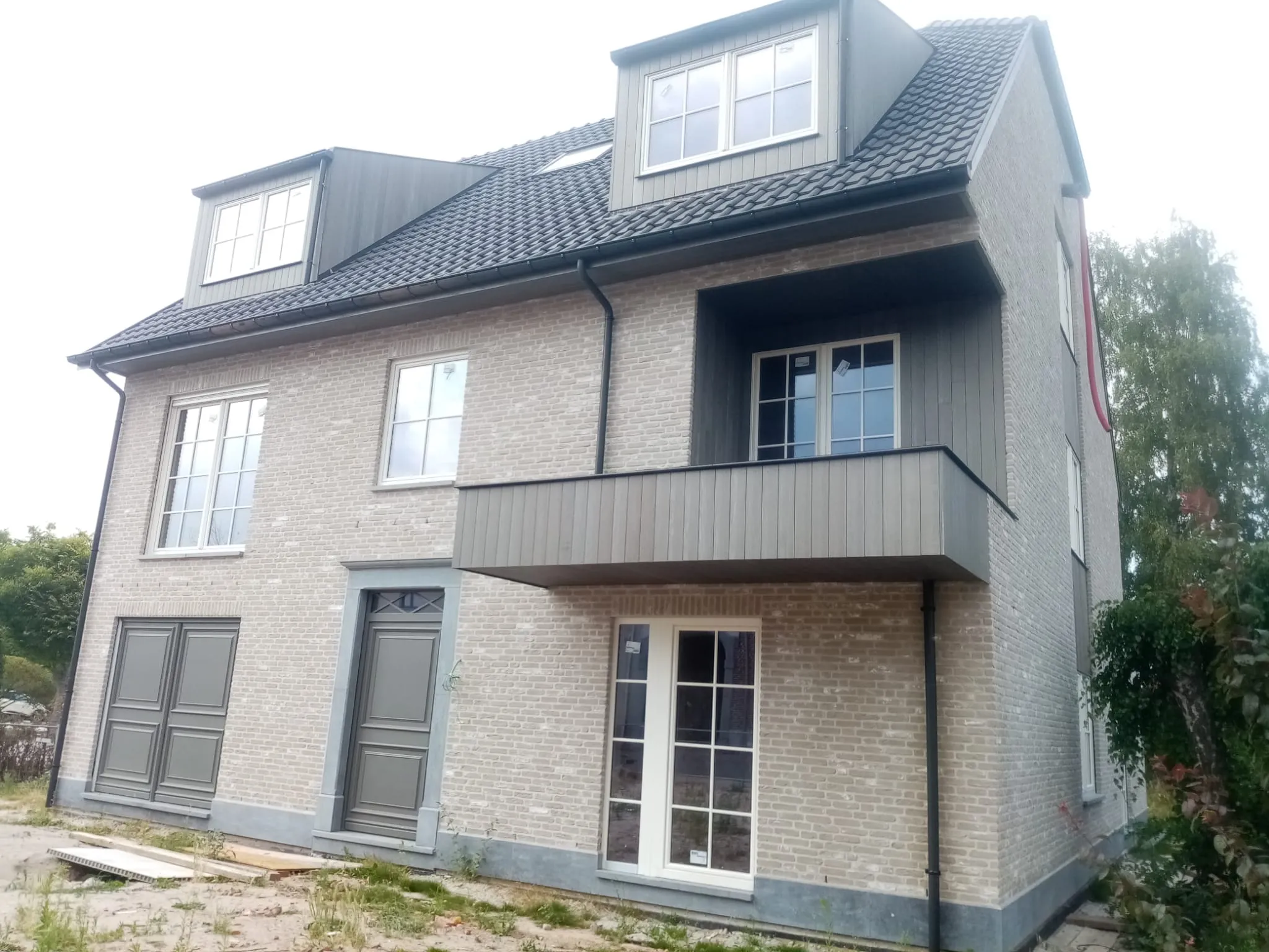 Afgewerkte gevel met balkon en dakkapellen in Holsbeek, Kortrijksebaan