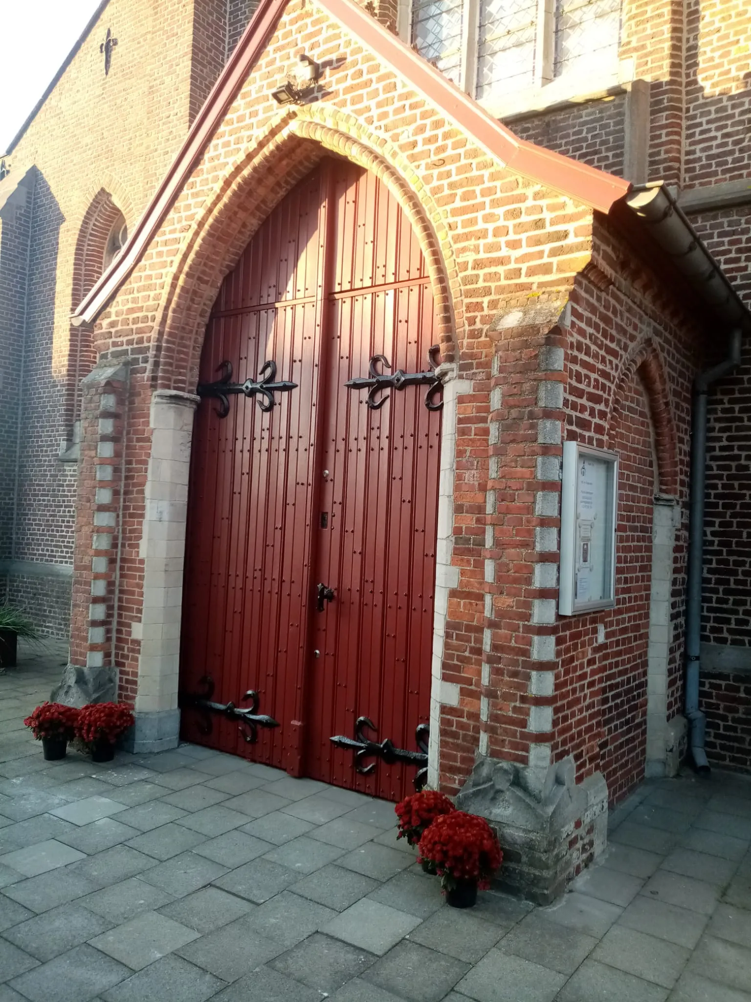 De hoofdingang van de kerk met een klassieke houten deur